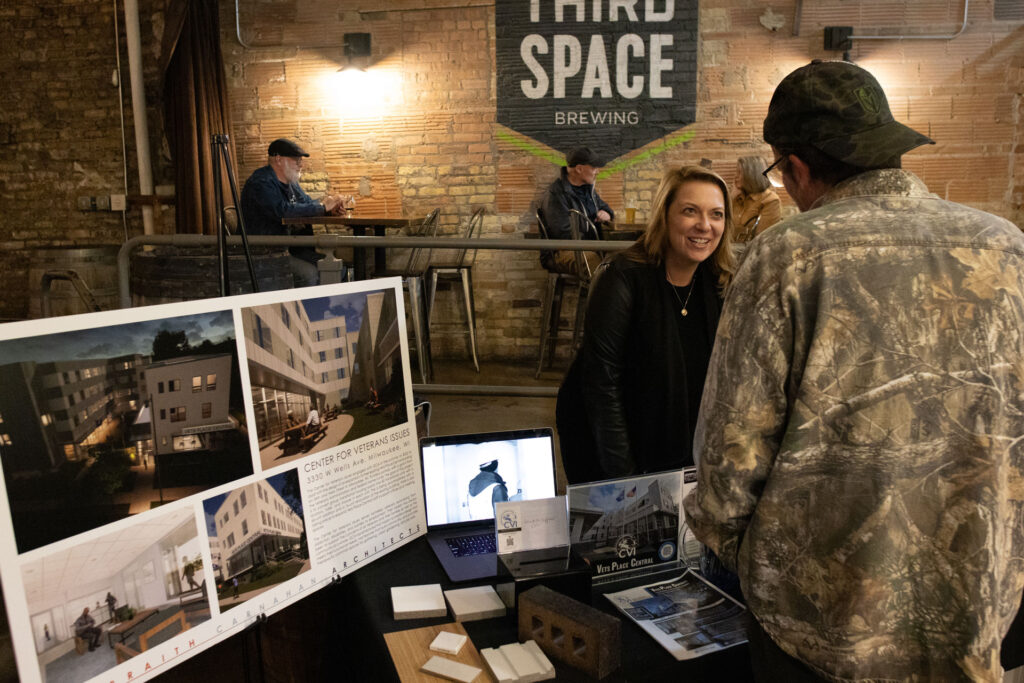 Sarah from the Center for Veterans Issues speaking with a veteran at the CVI information table inside Third Space Brewing.