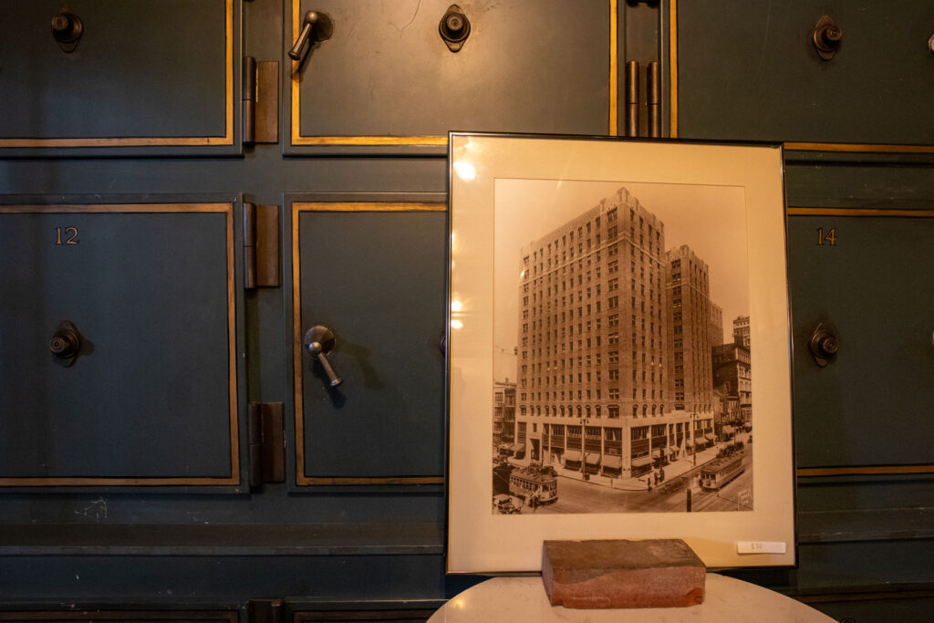 Framed historic Milwaukee building photo displayed in front of large metal safe deposit drawers.