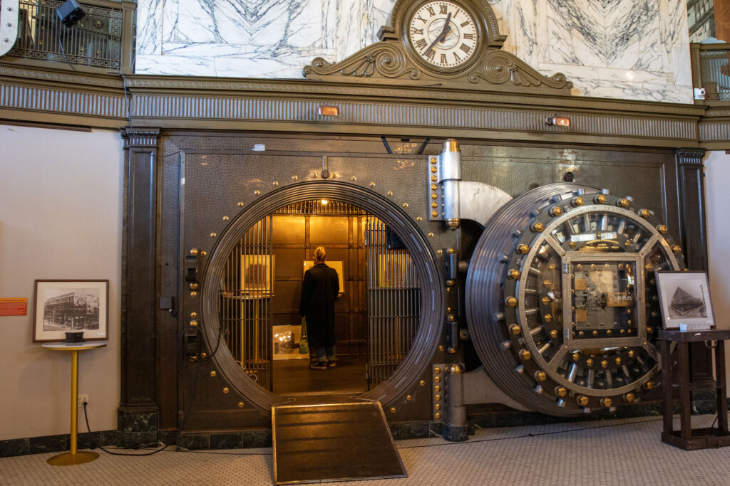 Visitor entering the large historic bank vault at the Milwaukee County Historical Society with framed photos inside.