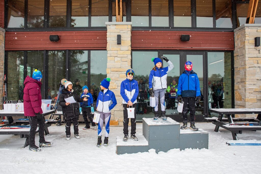 Young skiers stand on a podium outside Lapham Lodge during an awards ceremony at the Lapham Loppet.