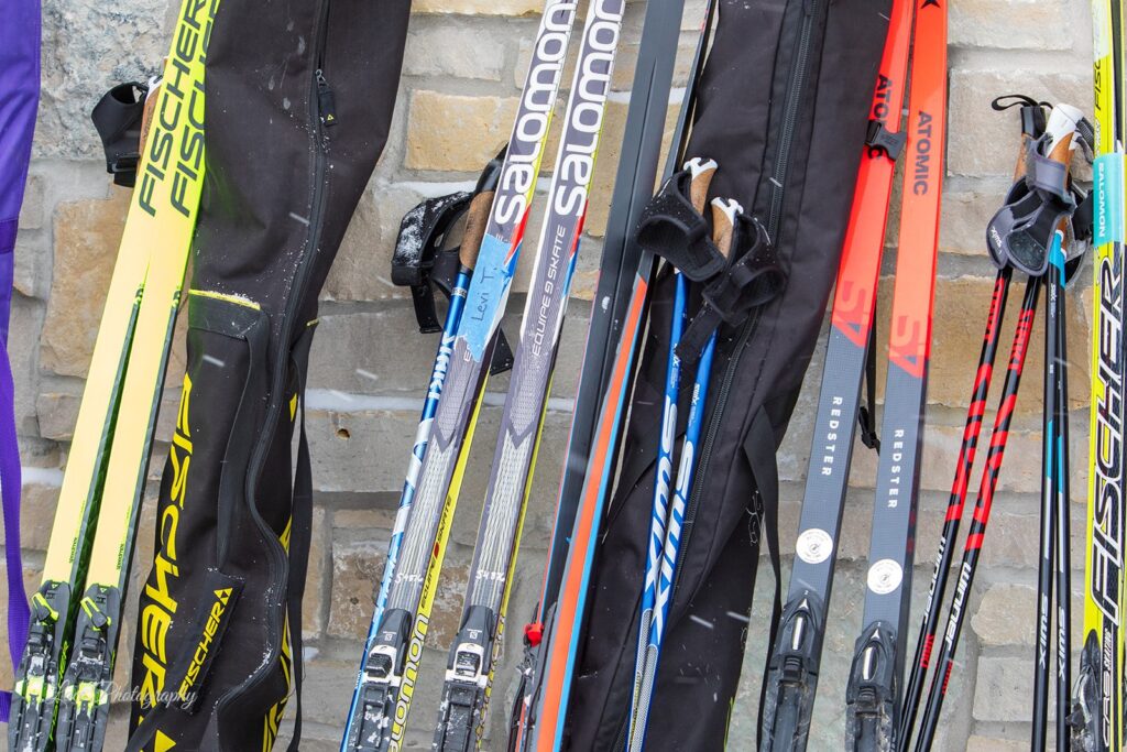Cross-country skis and poles lined up against a stone wall outside Lapham Lodge during the Lapham Loppet.