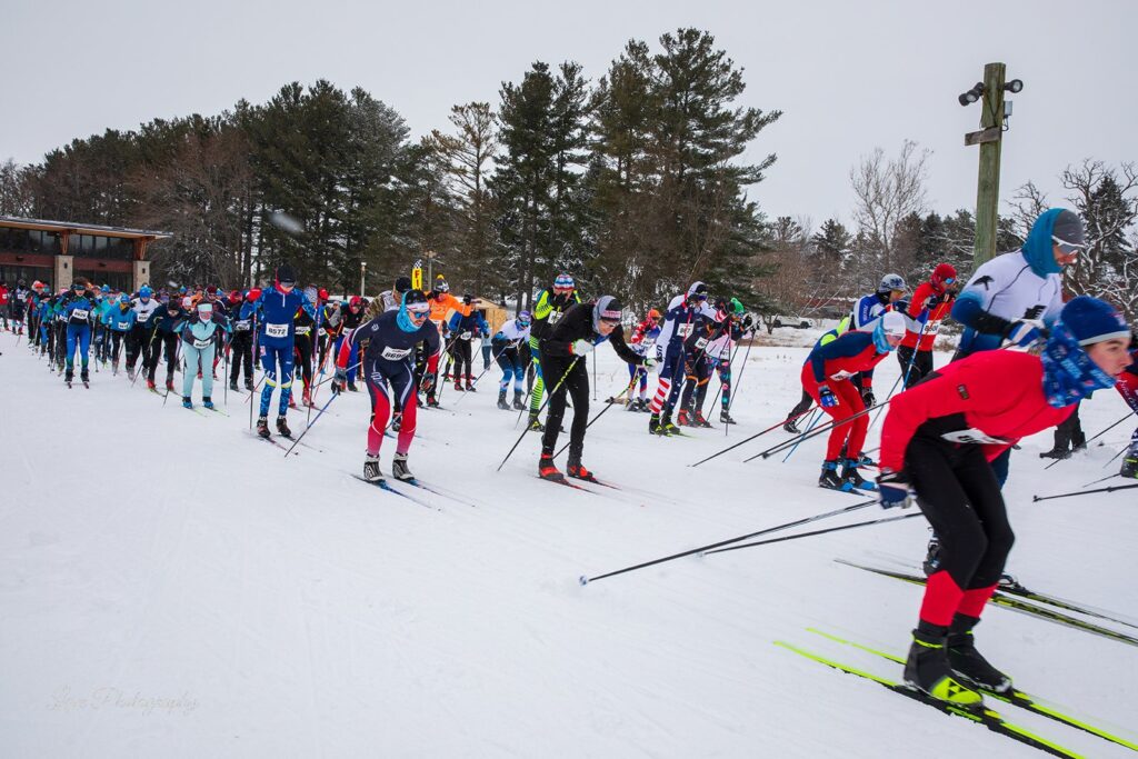 A large group of cross-country skiers launch from the start line at the Lapham Loppet at Lapham Peak.