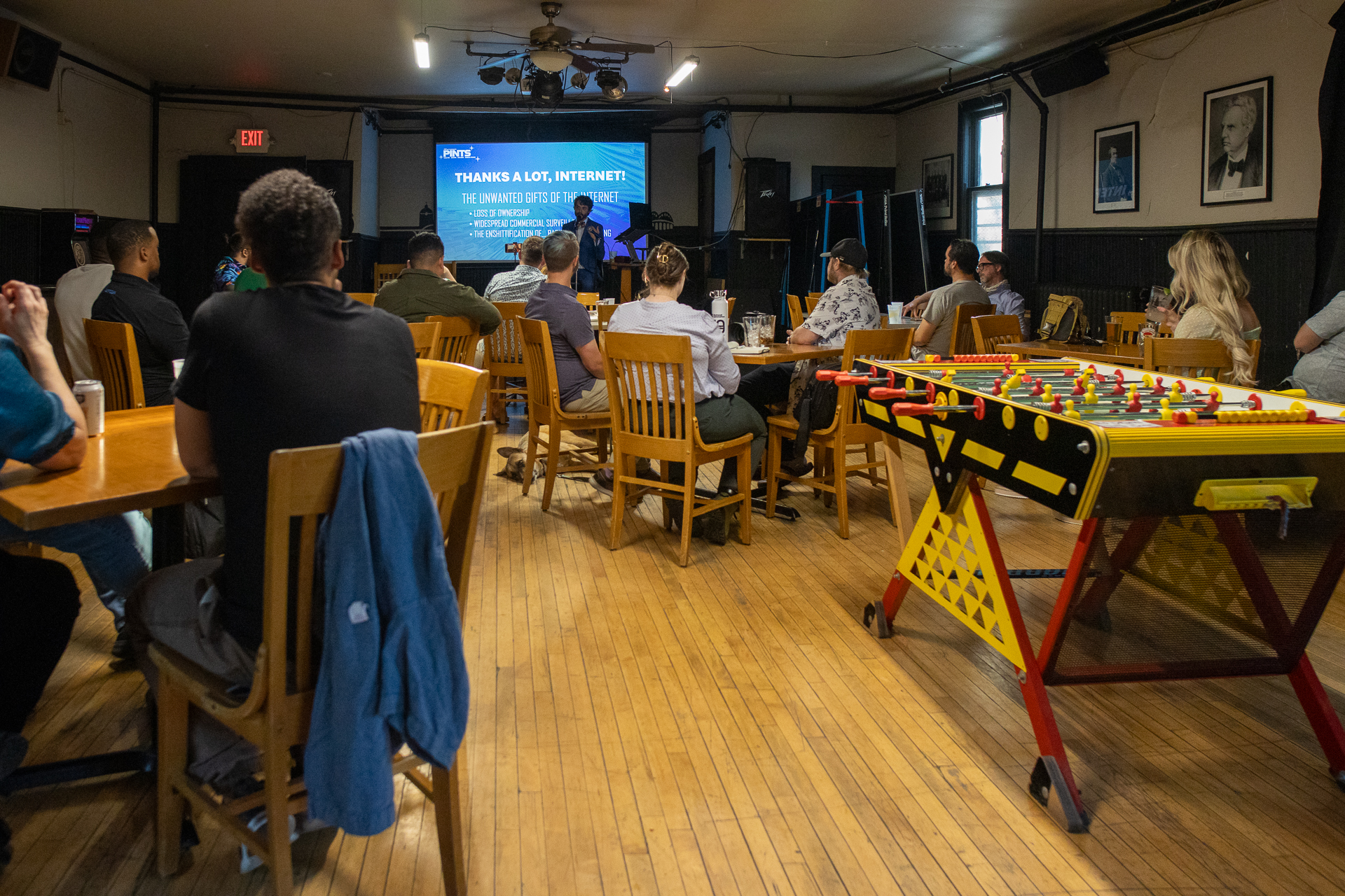 The main room at Puddler's Hall in Bay View, Milwaukee, with attendees seated and a foosball table during the PINTS event